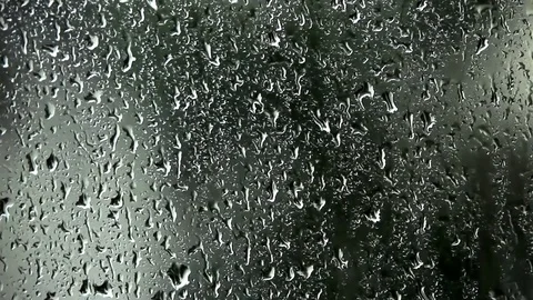 Close up of rain dropping on glass in bad weather blurred background Stock Footage 74734785