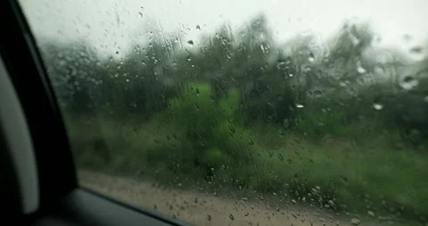 Close up of rain drops on car window during forest road trip with audio included Stock Footage 340828643