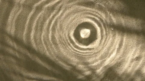 Close-up rain drops falling and splashing in water, leaf shadow on sand texture Stock Footage 254762075
