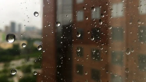 Close-up of rain drops falling down a window pane. Stock Footage 107754061