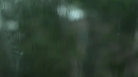 Close Up Rain Drops on Window with Blurred Green Trees. rainfall and nature Stock Footage 340806656