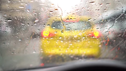Close up of rain drops on windshield. Standing on a street behind yellow car Stock Footage 80286541