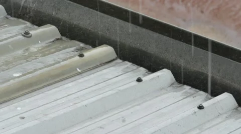 Close-up of rain falling on and rolling off a roof and gutter on a house. 스톡 동영상 65729114