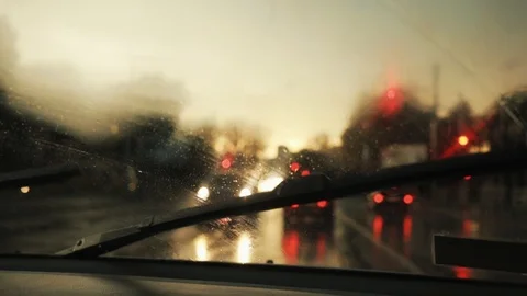 Close up rain flows and wipers on the front windshield glass window of car on Stock Footage 94531954