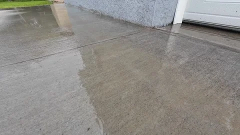 Close Up Rain Splashing In A Puddle Near A Garage Door, 4K Video stock 248475615