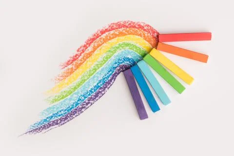 Close up of rainbow gradient made of pastel crayon chalks over the colorful t Fotos Stock