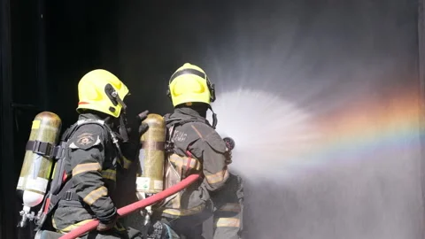 Close up rainbow reflection from water spraying from fireman team Stock-Footage 156980698