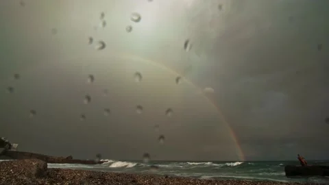 Close-up of a rainbow in the sky over the sea during a storm, droplets on the Stock Footage 220632585