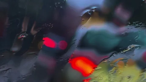 Close-up of raindrops and sleet on windscreen with blurred city lights Stock Footage 279403736