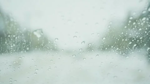 Close-up of raindrops on a car window during rain or snow Stock Footage 329192230