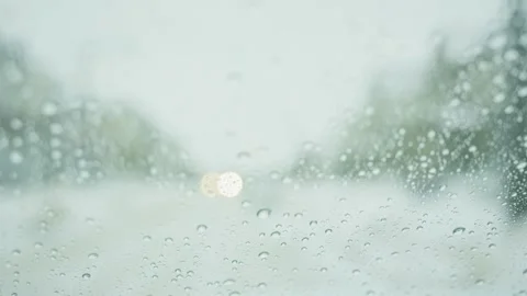 Close-up of raindrops on a car window during rain or snow Stock Footage 329192252