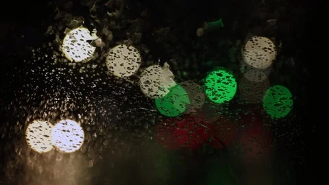 Close up. Raindrops on car windshield. Blurred background of traffic light. Video stock 265845477