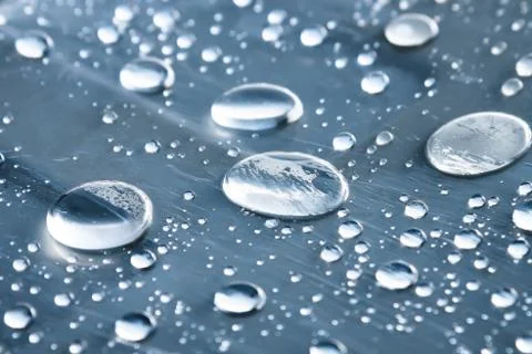 Close-up of raindrops of different sizes on the surface covered with cling film Stock Photos