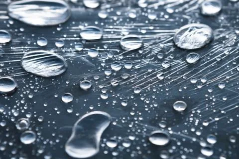 Close-up of raindrops of different sizes on the surface covered with cling film Stock Photos