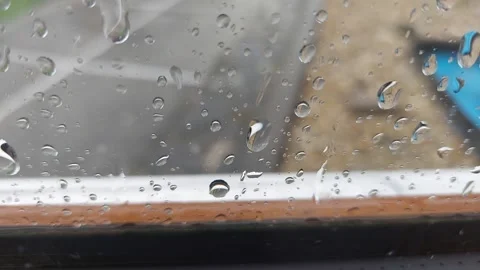 Close-up of Raindrops Dripping Down Window Glass During Rainstorm Stock Footage 333642429