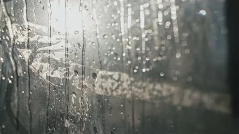 Close-up of raindrops dripping from the glass. Small raindrops run down the Stock Footage 213325655