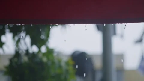 Close up on raindrops falling down from folding store canopy or roof sunshade Stock Footage 293705832