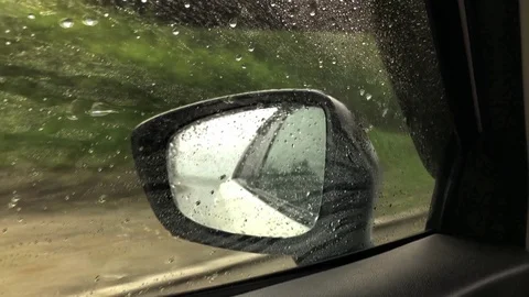 Close-up of raindrops on the side window of the car while driving Stock Footage 113326231