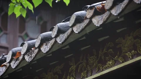 Close-up of raindrops sliding down the roof tiles of an ancient building. 스톡 동영상 335921187
