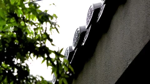 Close-up of raindrops sliding down the roof tiles of an ancient building. 스톡 동영상 335921218