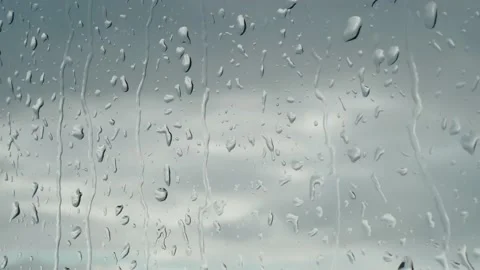 Close up of raindrops water drops dripping on wet window glass during rain on Stock Footage 201617814