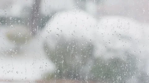 Close up of raindrops on a window with blurred snow outside Stock Footage 328220183
