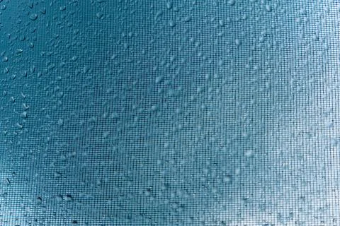 Close-up of raindrops on a window glass with blurred city lights reflecting i Stock Photos