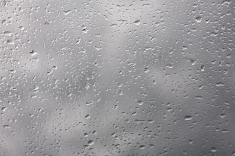 Close-up of raindrops on a window pane with a cloudy sky background Foto stock