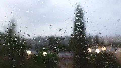 Close-up of raindrops on a window pane, viewed from inside the room. Stock Footage 195412857