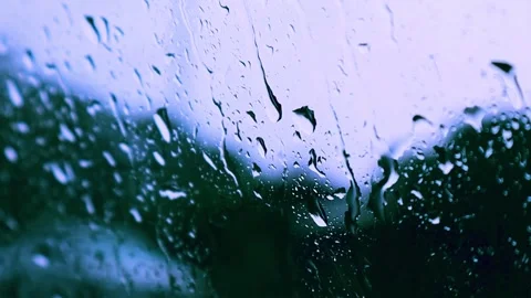 Close‑Up Raindrops on Window with Soft Focus and Blue Hue Stock Footage 325416424