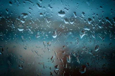 Close-up of raindrops on a windowpane with a blurred background of an urban.. Stock Photos