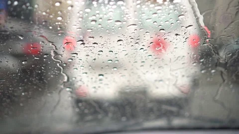 Close up of raindrops on windscreen. White van in front starts to move in Stock Footage 79092591