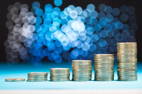 Close-up Of Raising Stack Of Coins With Bokeh Background Stock Photos