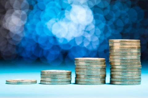 Close-up Of Raising Stack Of Coins With Bokeh Background Stock Photos