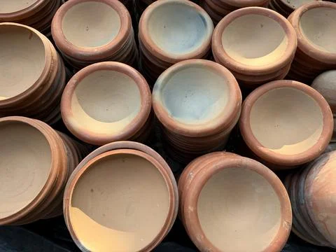 Close range shows various round earthenware bowls, revealing their textured s Фото