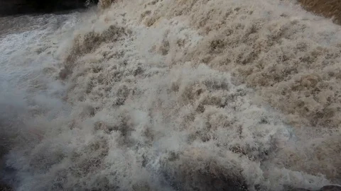 Close up rapid brown river water on man made cascades Stock Footage 120456572