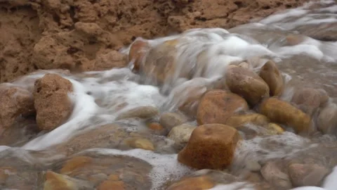 Close-Up of Rapid Water Cascading Over Smooth Rocks in an Eroded Dirt Channel Vídeos de archivo 334181916