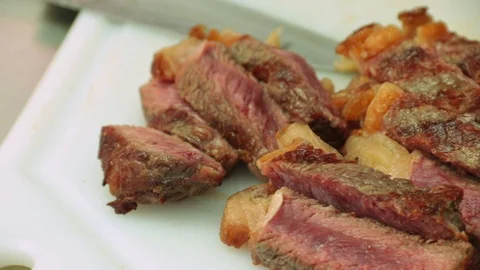 Close up of rare steak slices served on a white cutting board Stock Footage 127715418