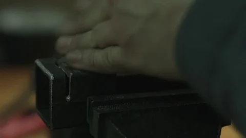 Close up of a rasp work on a piece of a cubical metal pipe held by a clamp. Stockbeeldmateriaal 74775559