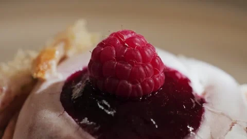 Close-up of raspberry cake slice topped with cream frosting and fresh raspberry Stock Footage 336059511