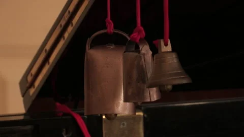 Close-up of rattles and a small bell, hanging from a red thread. Stock Footage 333399202