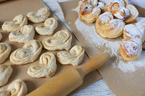 Close-up of raw and cooked buns with powdered sugar Stock Photos