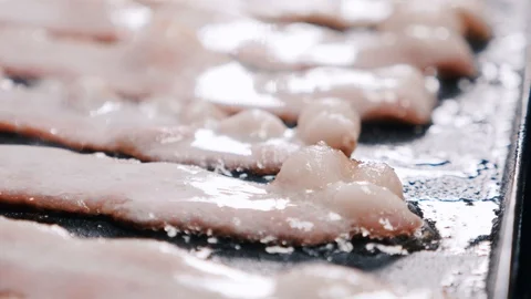 Close up of raw bacon frying over cooking oil Video stock 102570253