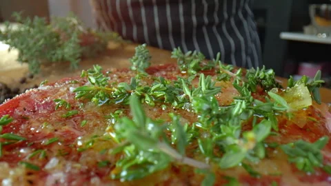 Close-up of raw beef steak The chef puts rosemary on the steak Food preparation. Stock Footage 277451950