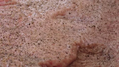 Close-up of Raw Beef Steak Seasoned with Salt and Pepper for BBQ Stock Footage 338213605