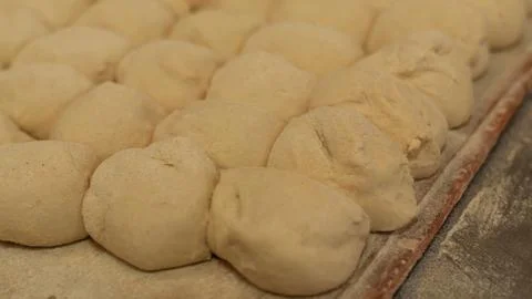 Close-up of raw bread dough balls on a floured tray Stock Photos