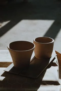 Close-up raw ceramic pottery cup drying on wooden table, clay texture Stock Photos