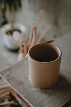 Close-up raw ceramic pottery cup drying on wooden table, clay texture Stock Photos