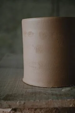 Close-up raw ceramic pottery cup drying on wooden table, clay texture Stock Photos