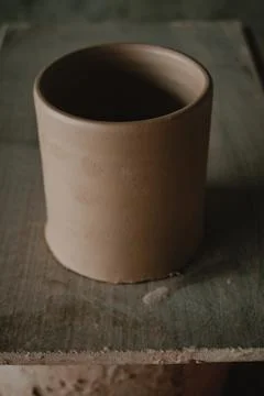Close-up raw ceramic pottery cup drying on wooden table, clay texture Stock Photos